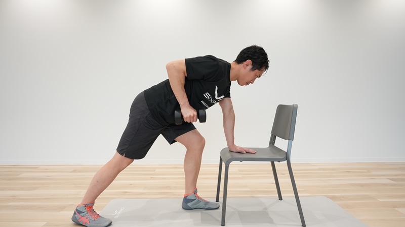 もう片方の手でダンベルを持ち、ひじの角度を約90°にし、ひじから先が地面の方を向いている状態をつくる。